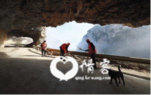保洁员在石板河村悬崖上的通村公路上清扫路面。