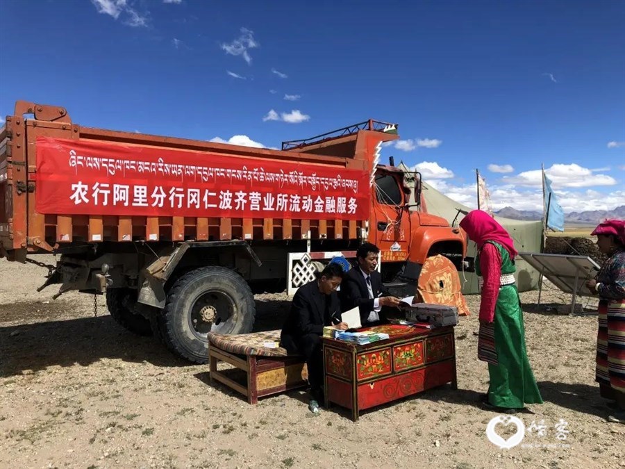 农行阿里冈仁波齐营业所的员工们正在为当地游牧民进行精准扶贫卡流动服务