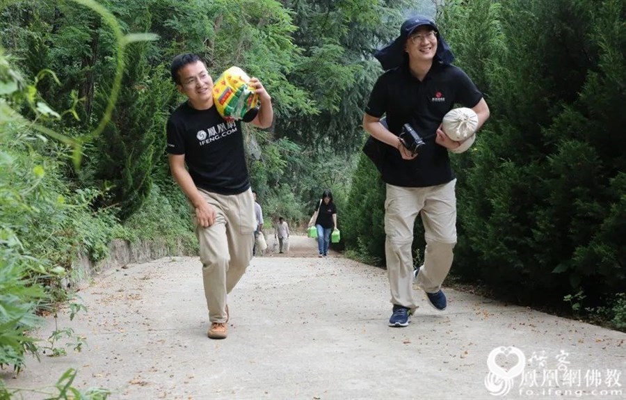 慰问终南山丰德寺,慧海公益团队将物资扛上山。(图片来源:凤凰网佛教)