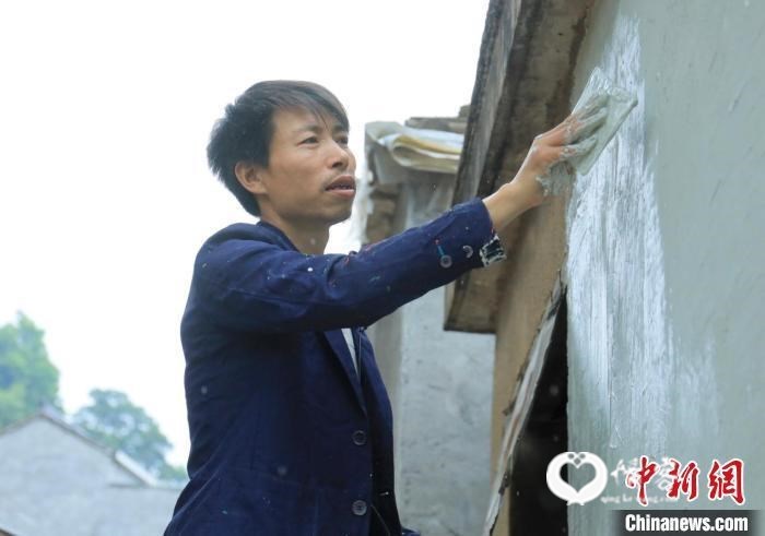 杨军昌为老房子刷墙 项菁 摄