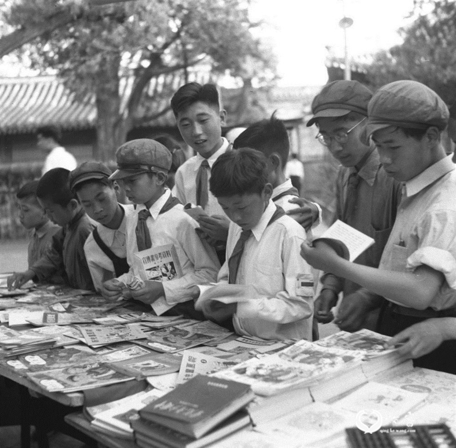1951年,北京市中山公园内新华书店售书亭为了庆祝六一国际儿童节,为儿童准备了大批儿童读物。图为儿童们在选购以九折出售的儿童读物。