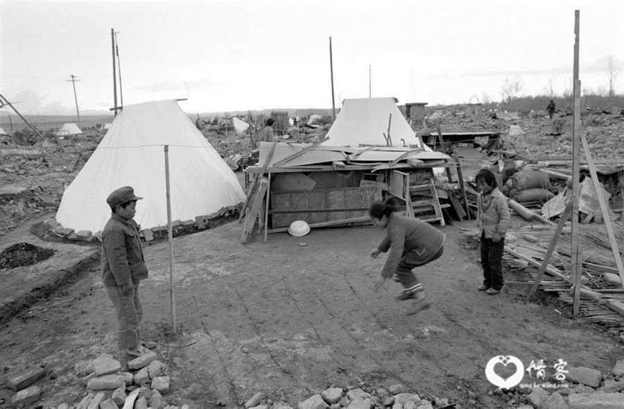 1990年4月,青海省海南地区发生6.9级强烈地震。图为灾区儿童在余震不断时玩起跳房子游戏。