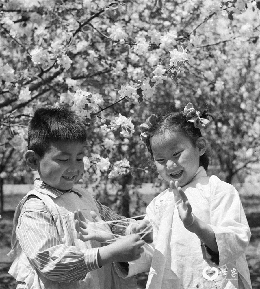 1962年5月,原哈尔滨亚麻纺织厂幼儿园的孩子在做翻花绳游戏。