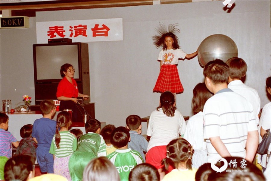 1998年5月31日,许多小学生来到中国科技馆学习科技知识,欢庆“六一”儿童节。这是科技馆工作人员帮助儿童体会人体静电反应。