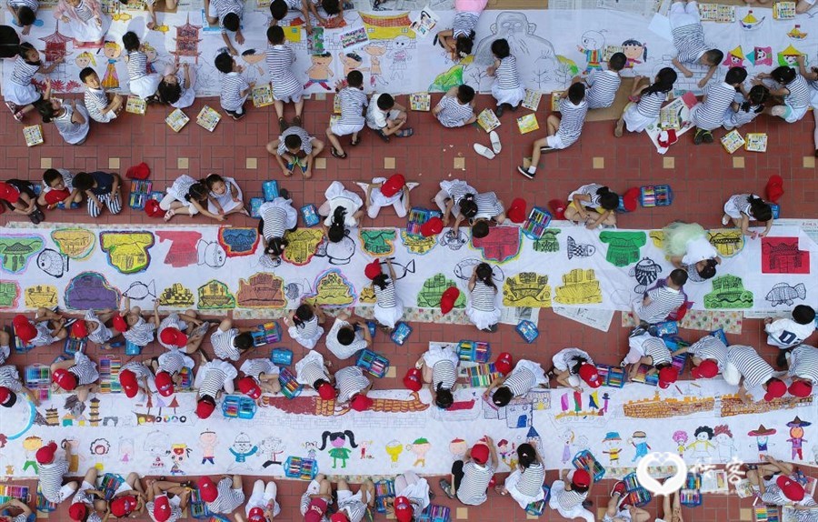 2017年5月31日,福建省泉州市鲤城区机关幼儿园的孩子们在百米长卷上绘画。